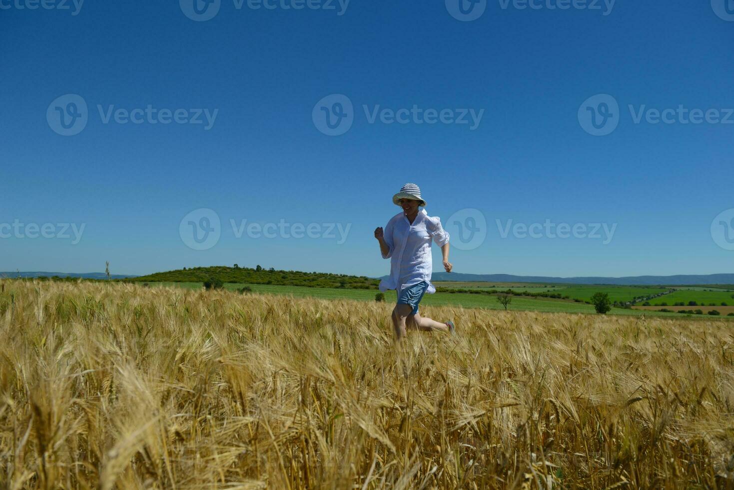 young woman in wheat field at summer photo