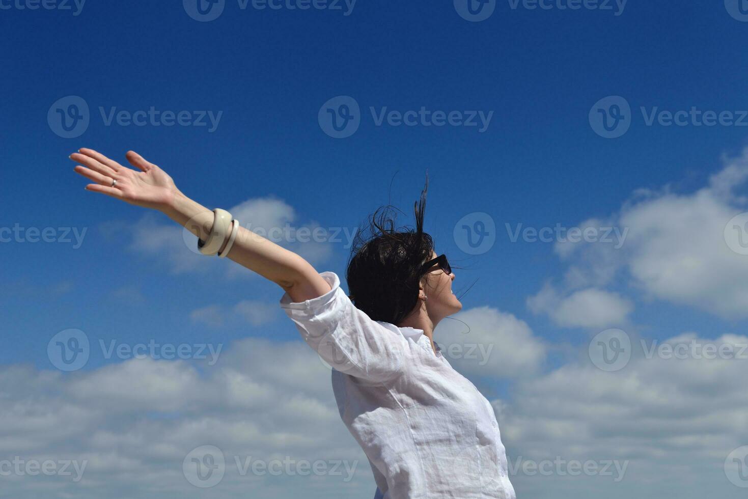 happy young woman with spreading arms to sky photo