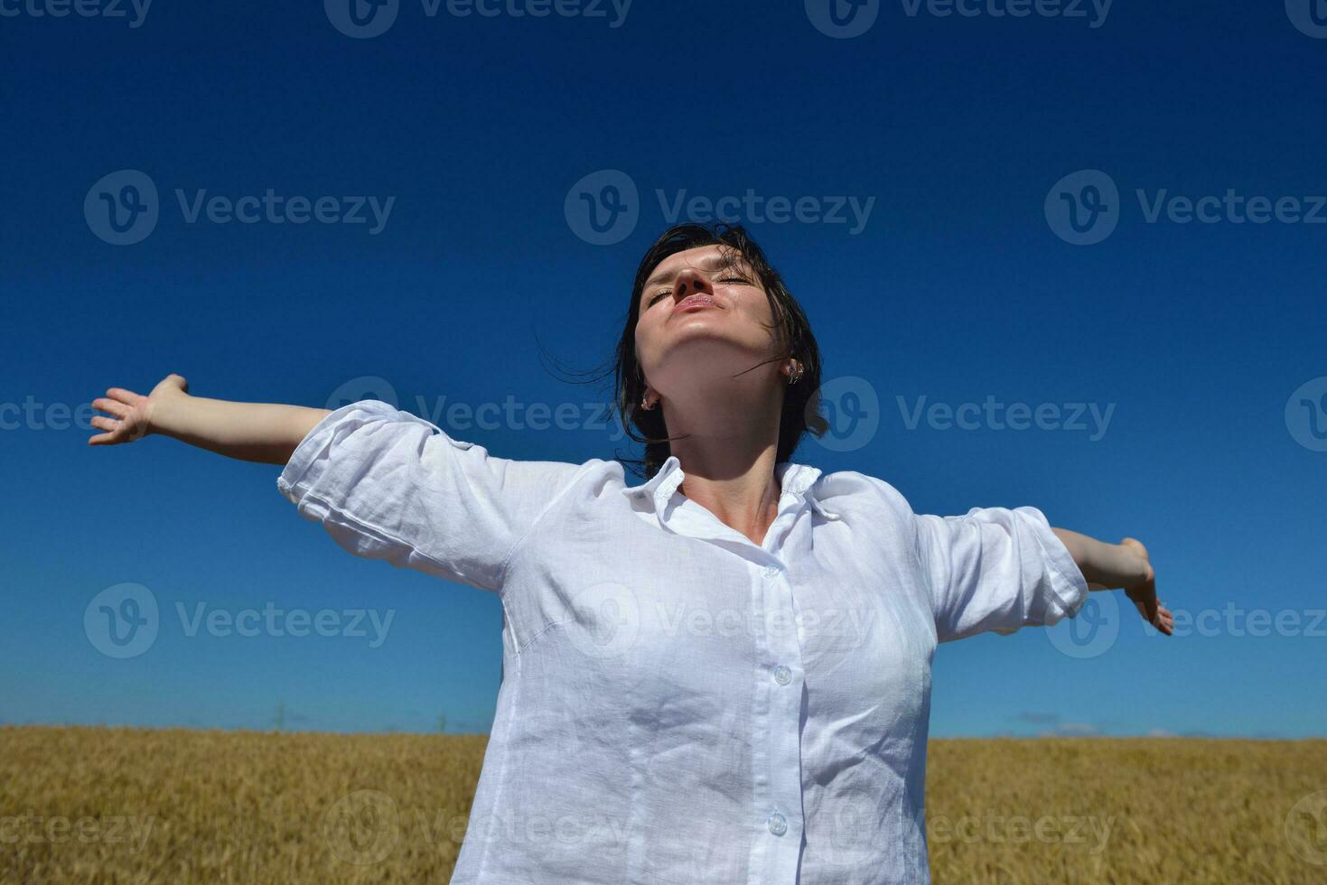 mujer joven en campo de trigo en verano foto