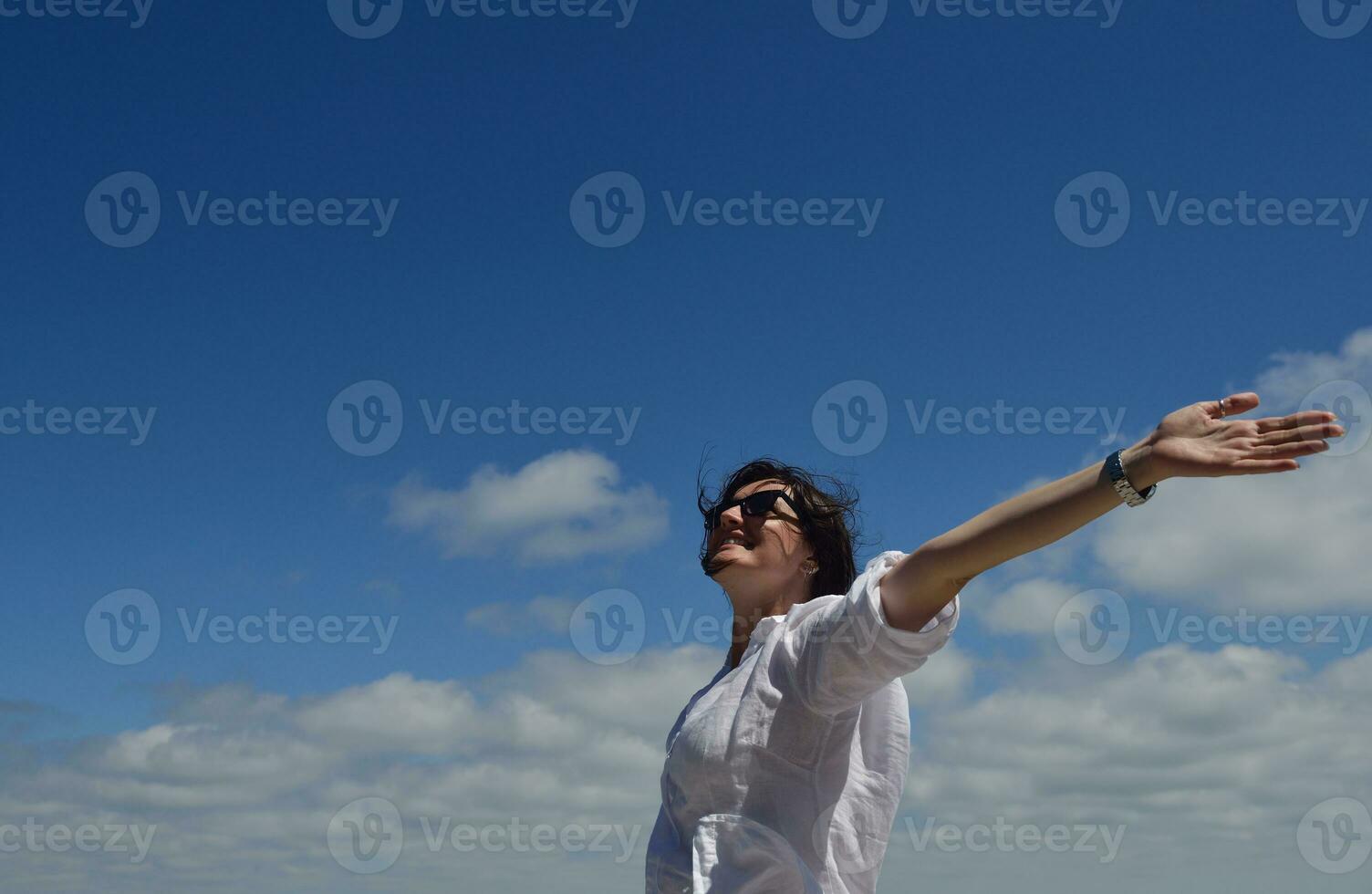 mujer joven feliz con los brazos extendidos al cielo foto