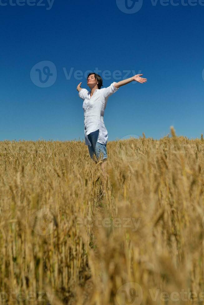 young woman in wheat field at summer photo