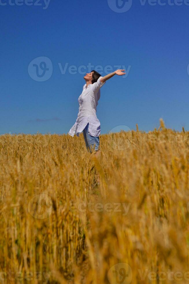 young woman in wheat field at summer photo