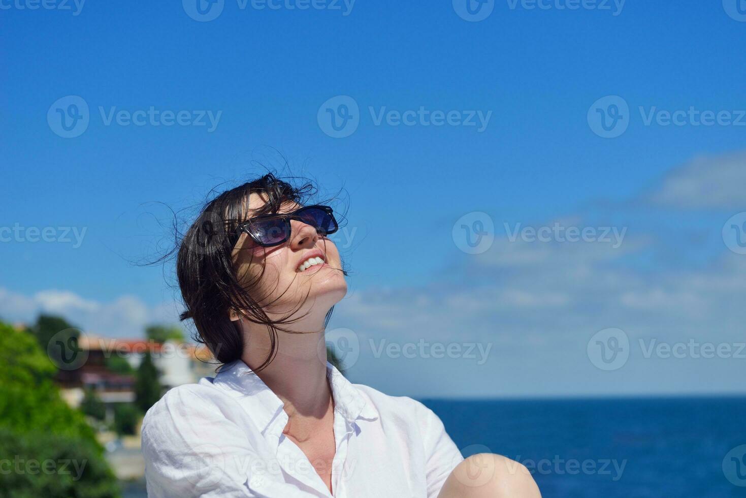 young woman with spreading arms to sky photo