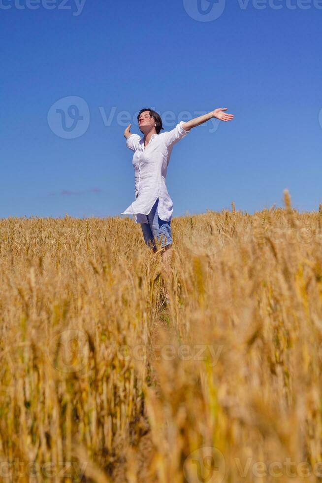 mujer joven en campo de trigo en verano foto