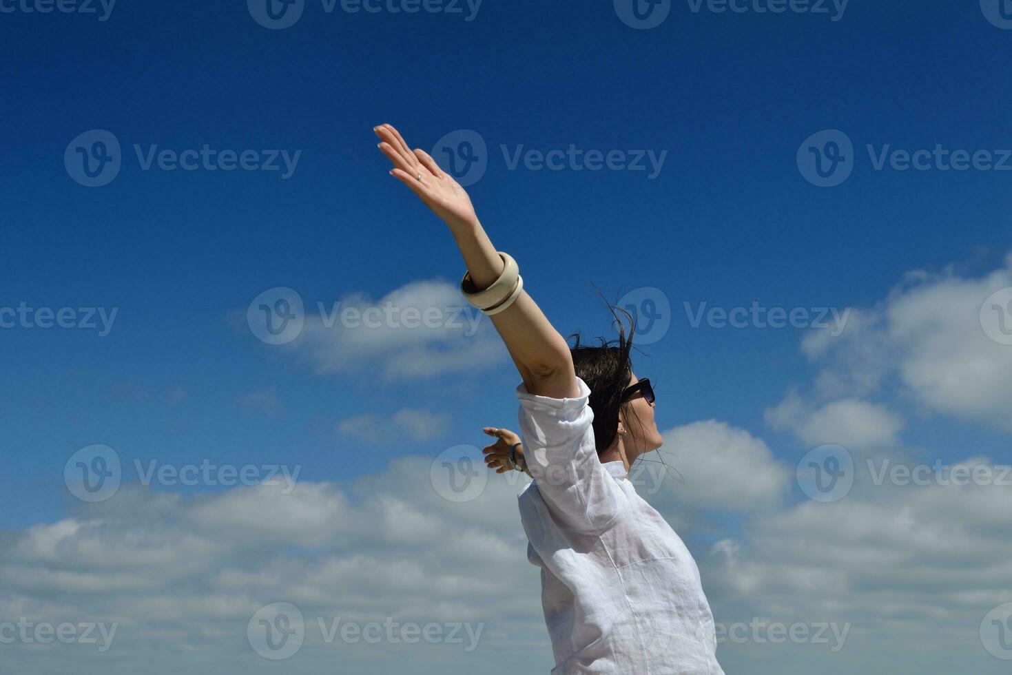 young woman with spreading arms to sky photo