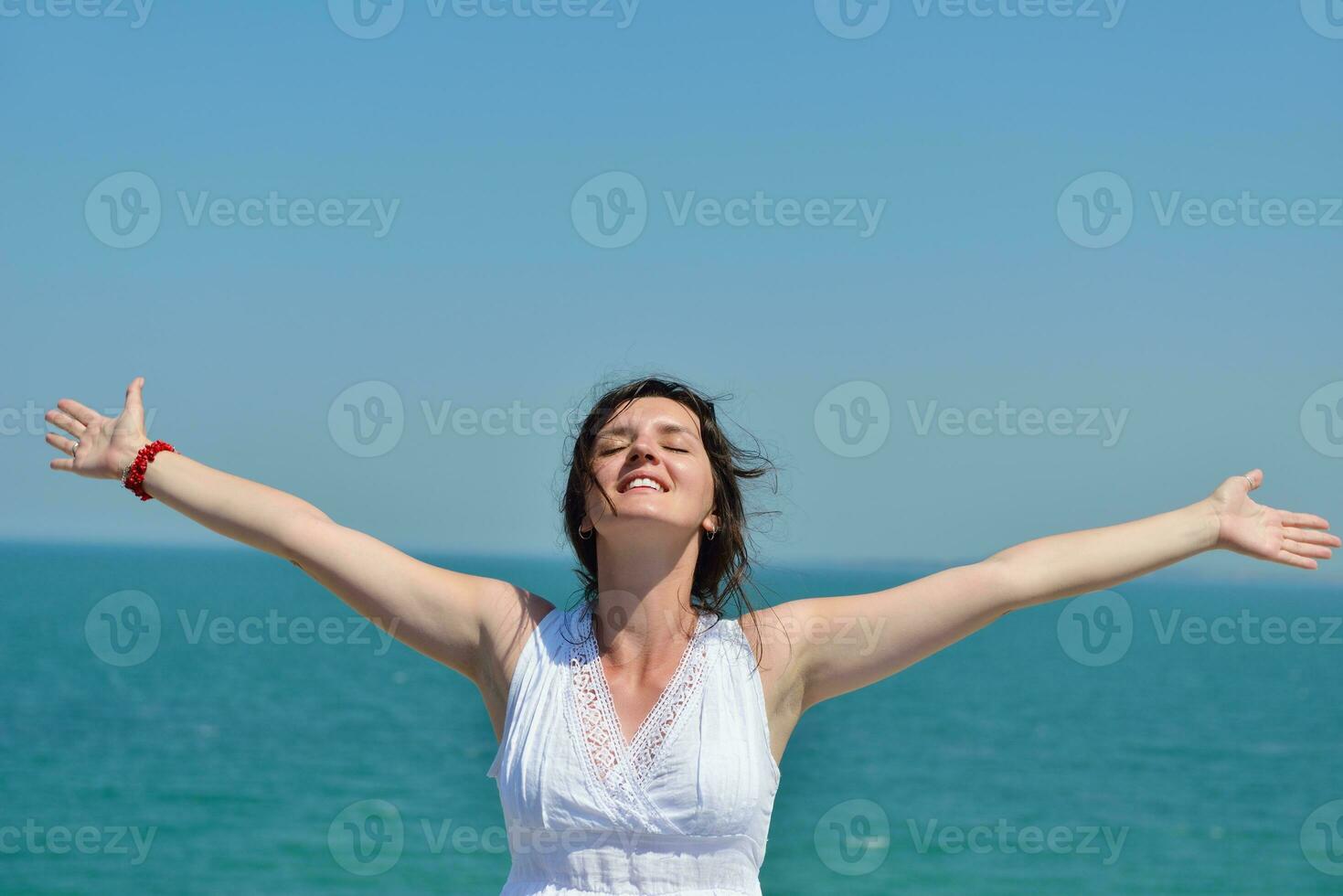 young woman with spreading arms to sky photo