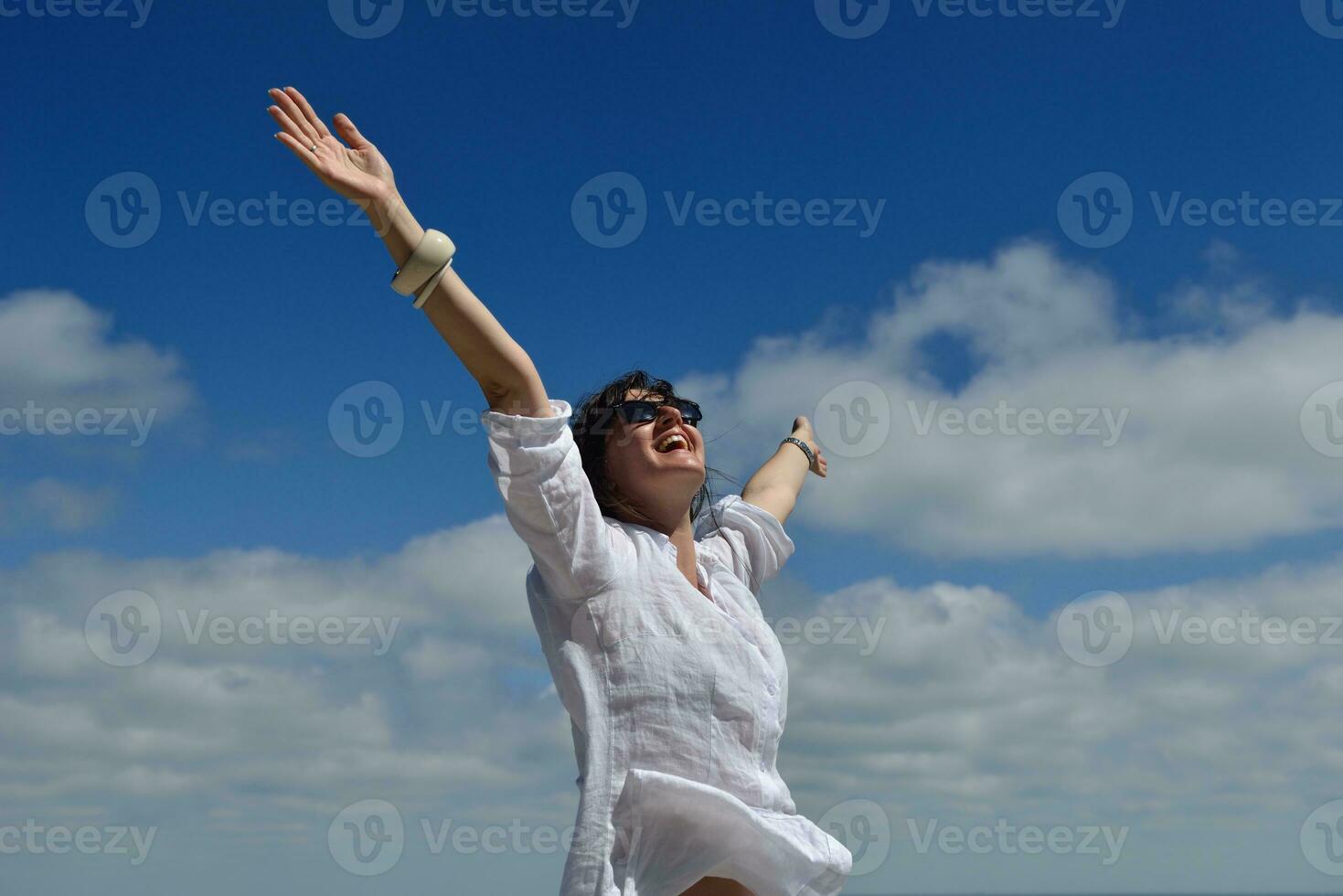 young woman with spreading arms to sky photo