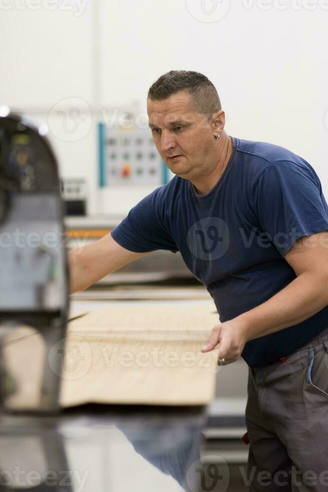 worker in a factory of wooden furniture photo