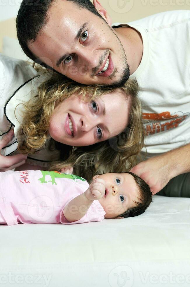 retrato interior con familia joven feliz y pequeño bebé lindo foto