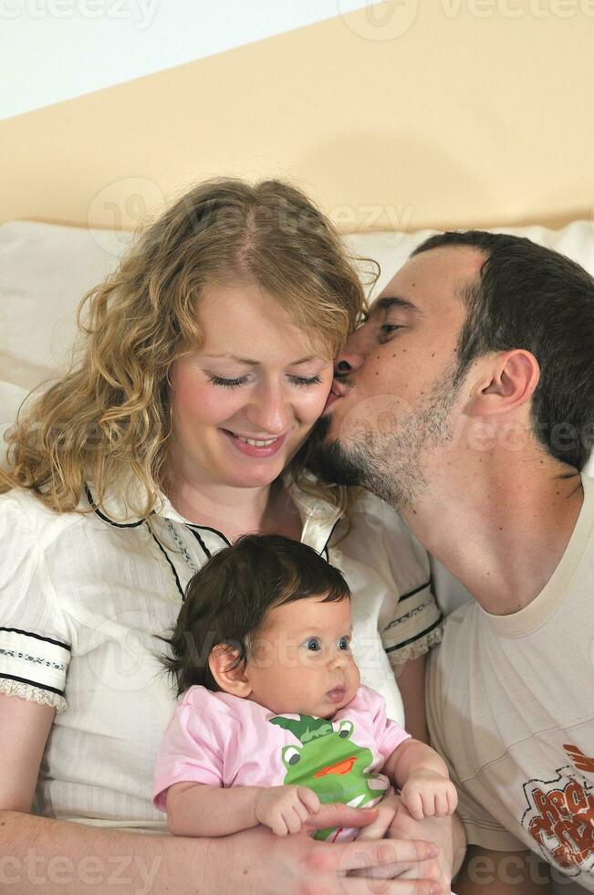 indoor portrait with happy young family and  cute little babby photo