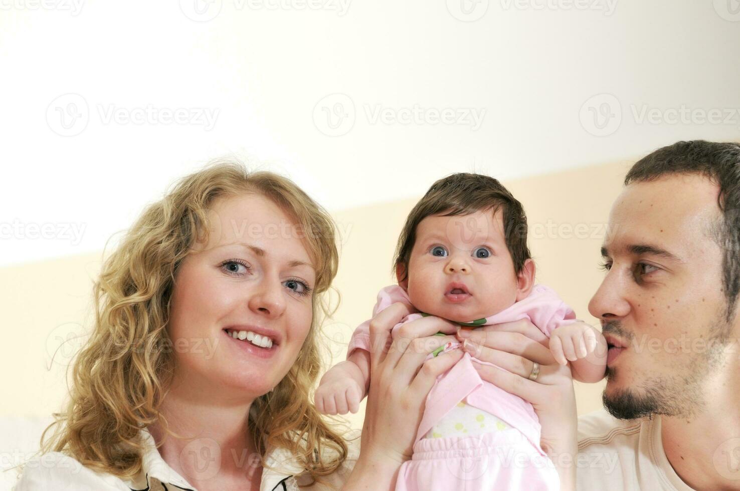 indoor portrait with happy young family and  cute little babby photo