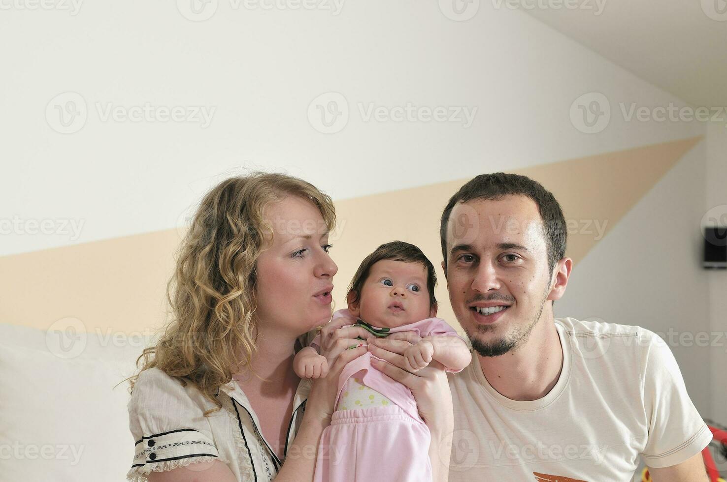 indoor portrait with happy young family and  cute little babby photo