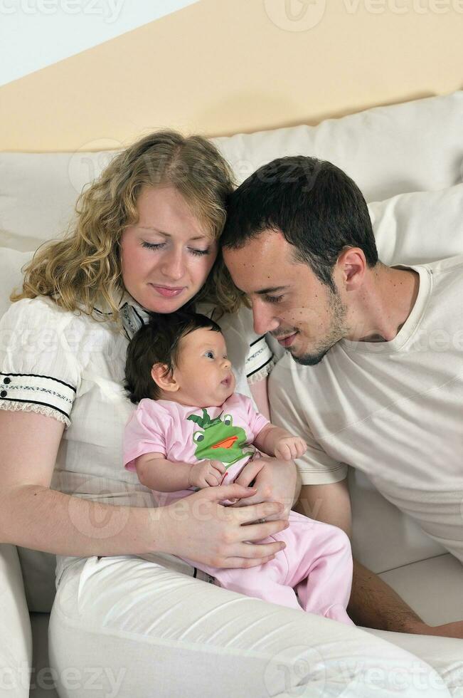 retrato interior con una familia joven feliz y un lindo bebé foto