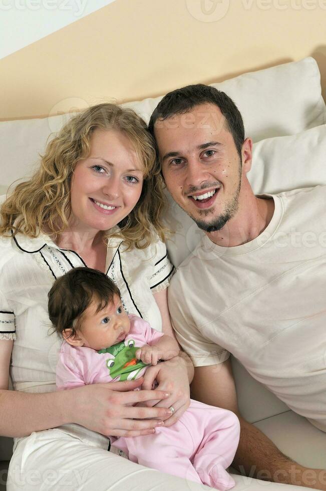 indoor portrait with happy young family and  cute little babby photo