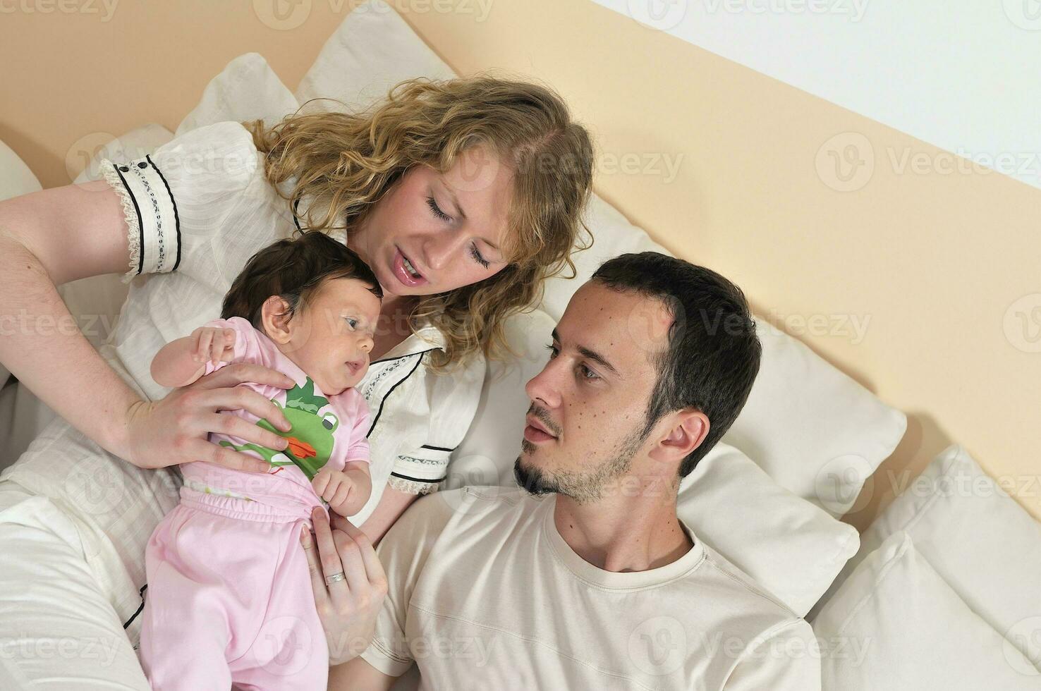 indoor portrait with happy young family and  cute little babby photo