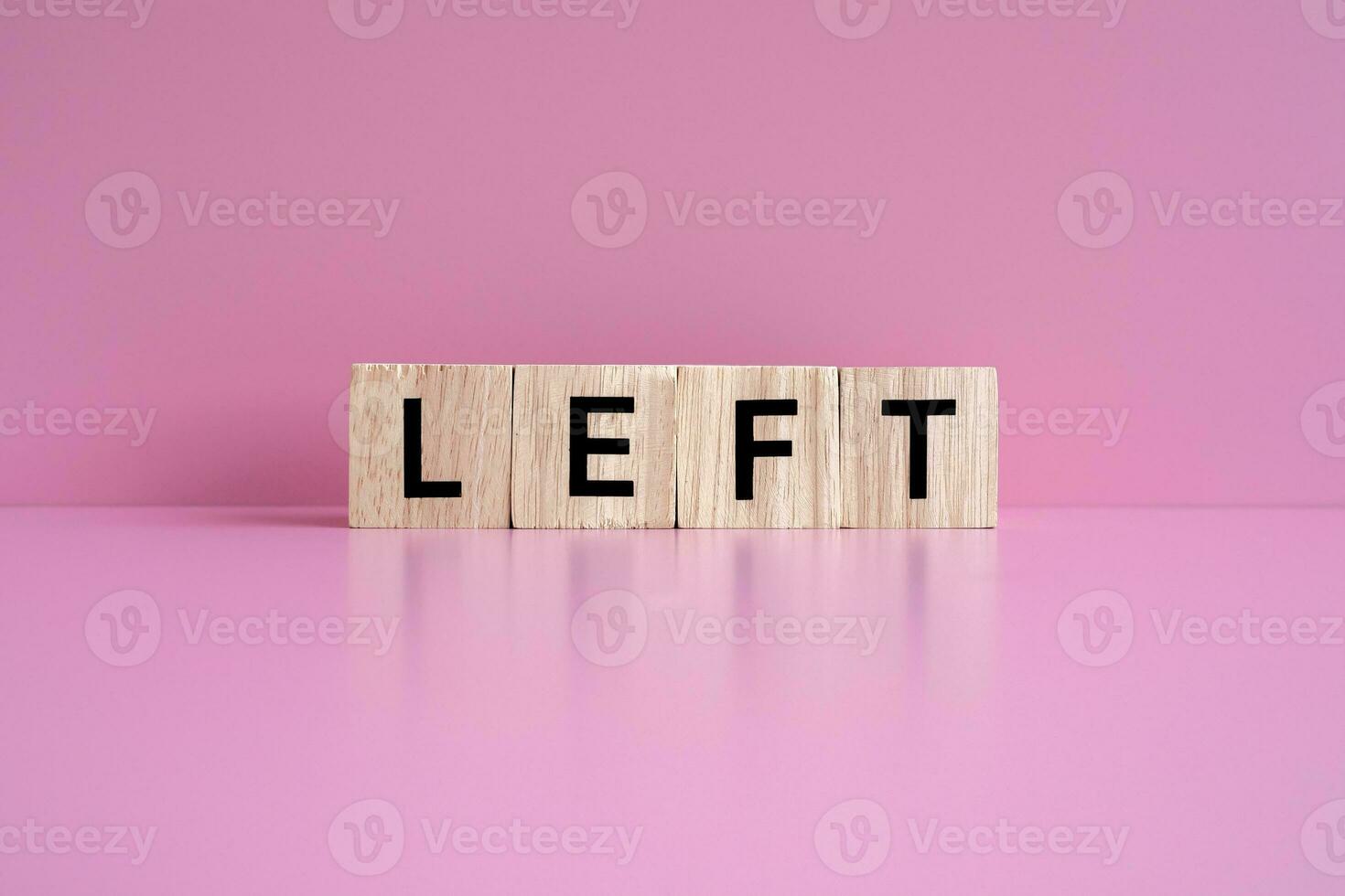 Wooden blocks form the text LEFT against a pink background. photo