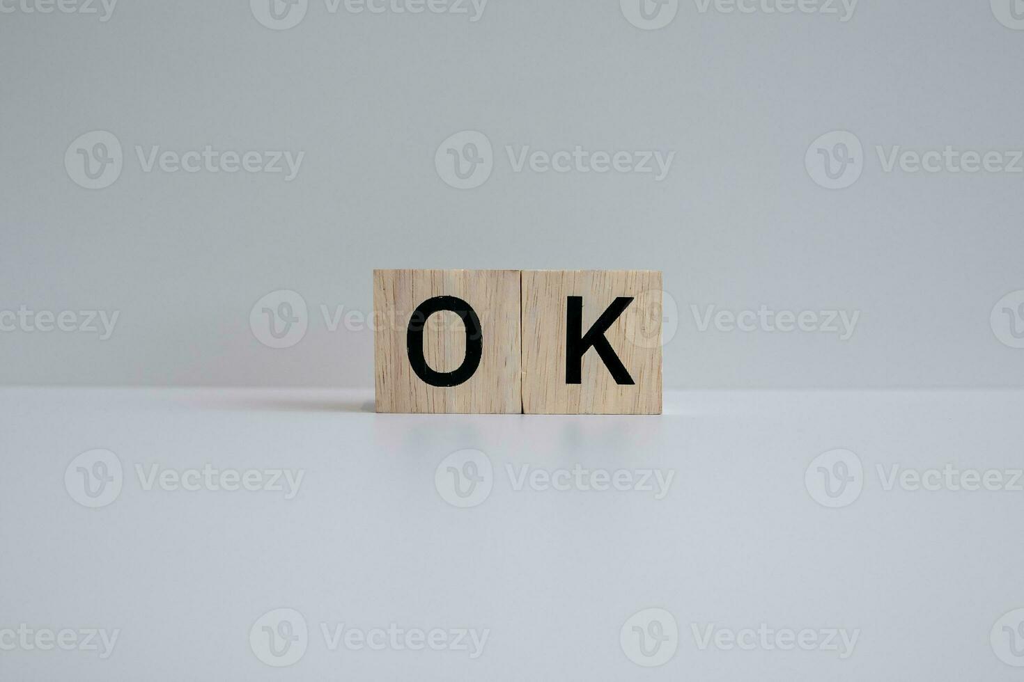 Wooden blocks form the text OK against a white background. photo