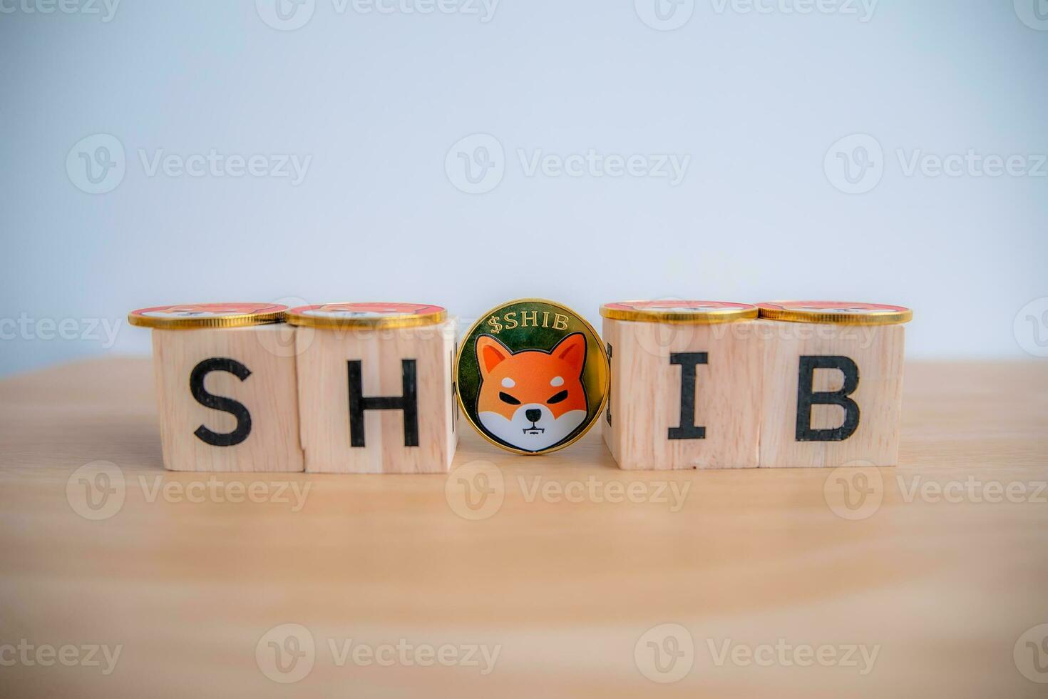 Wooden block written SHIB in front of the Shina inu token with 1 coin in the middle, close-up. photo