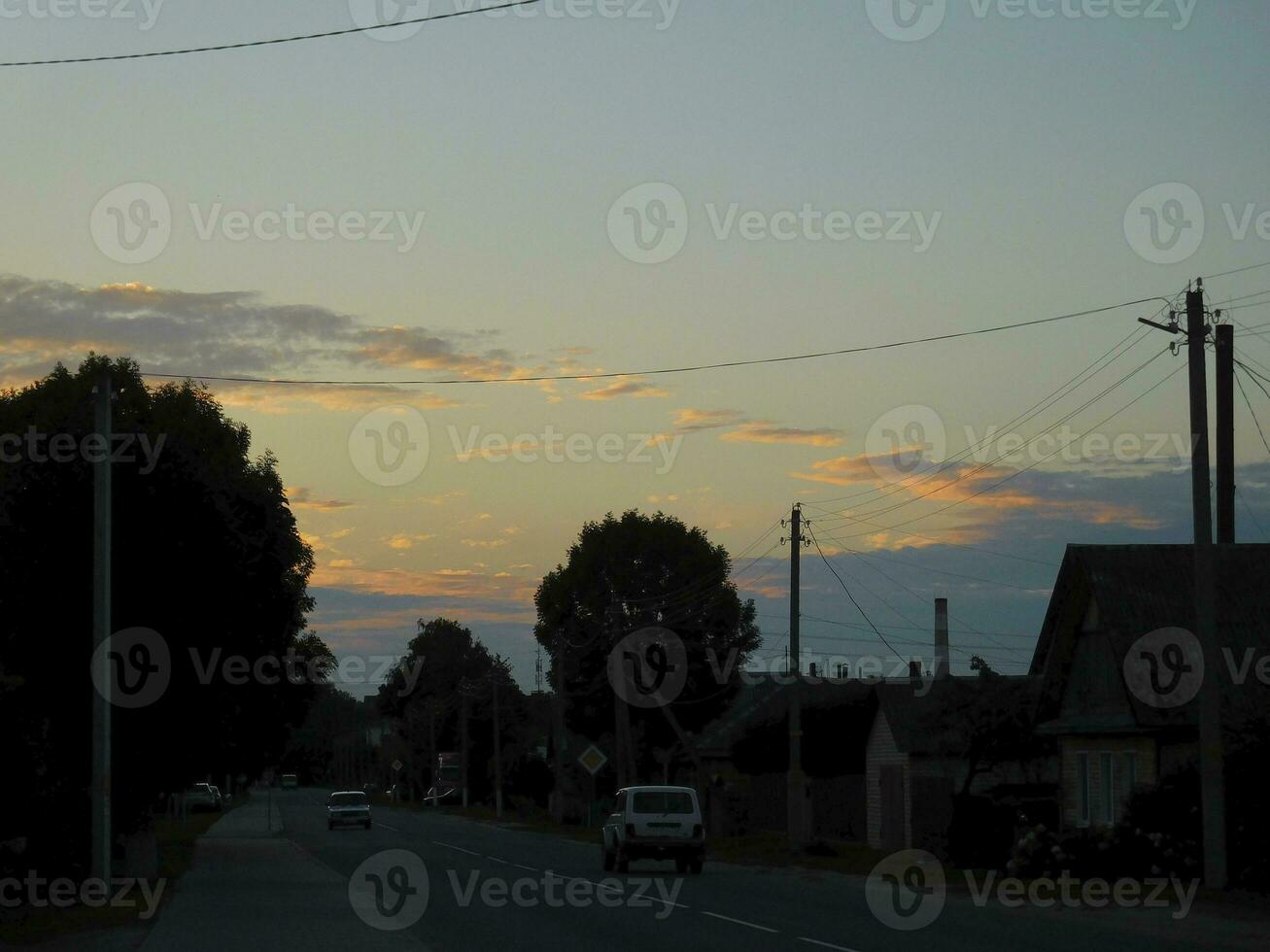beautiful sky with clouds in the evening above the road with cars photo