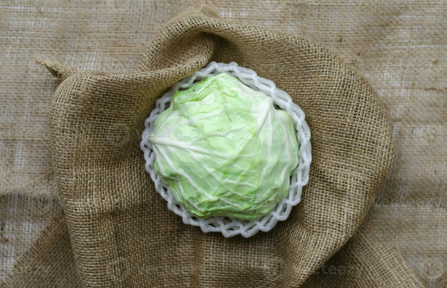 fresh cabbage wrap by foam on a brown fabric background photo