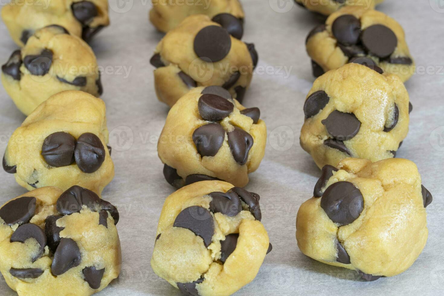 Balls of Chocolate Chip Cookie Dough with Extra Chips Ready for the Oven photo