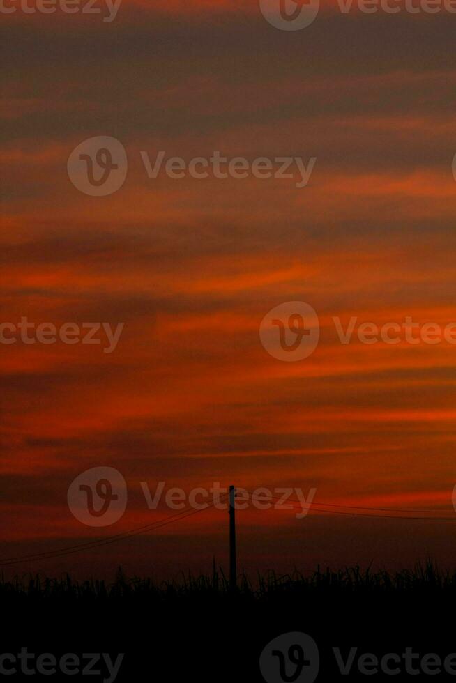 atmosphere of the evening sky as the sun sets, the sky is red, looks scary but warm, romantic atmosphere in the countryside of Thailand. photo