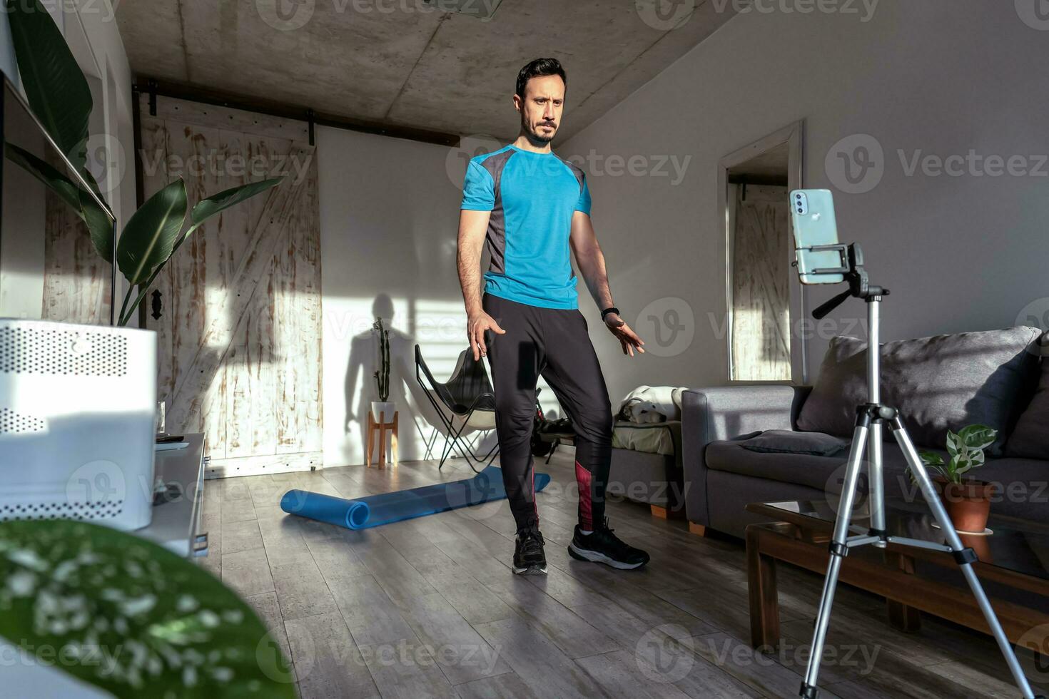 Trainer streaming online workout with phone at home. photo