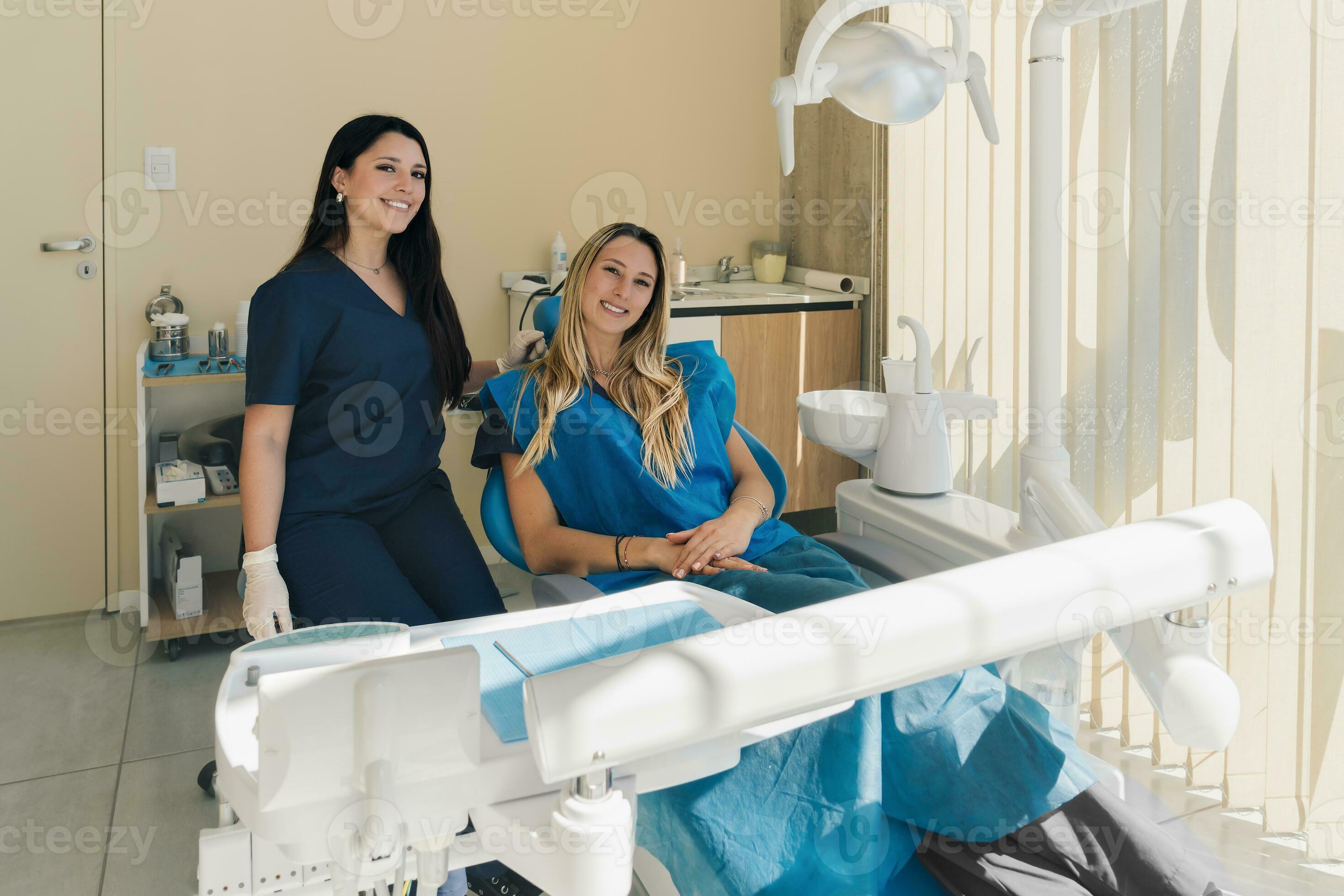 Latin young Dentist And Female blonde Patient Posing In Modern Clinic