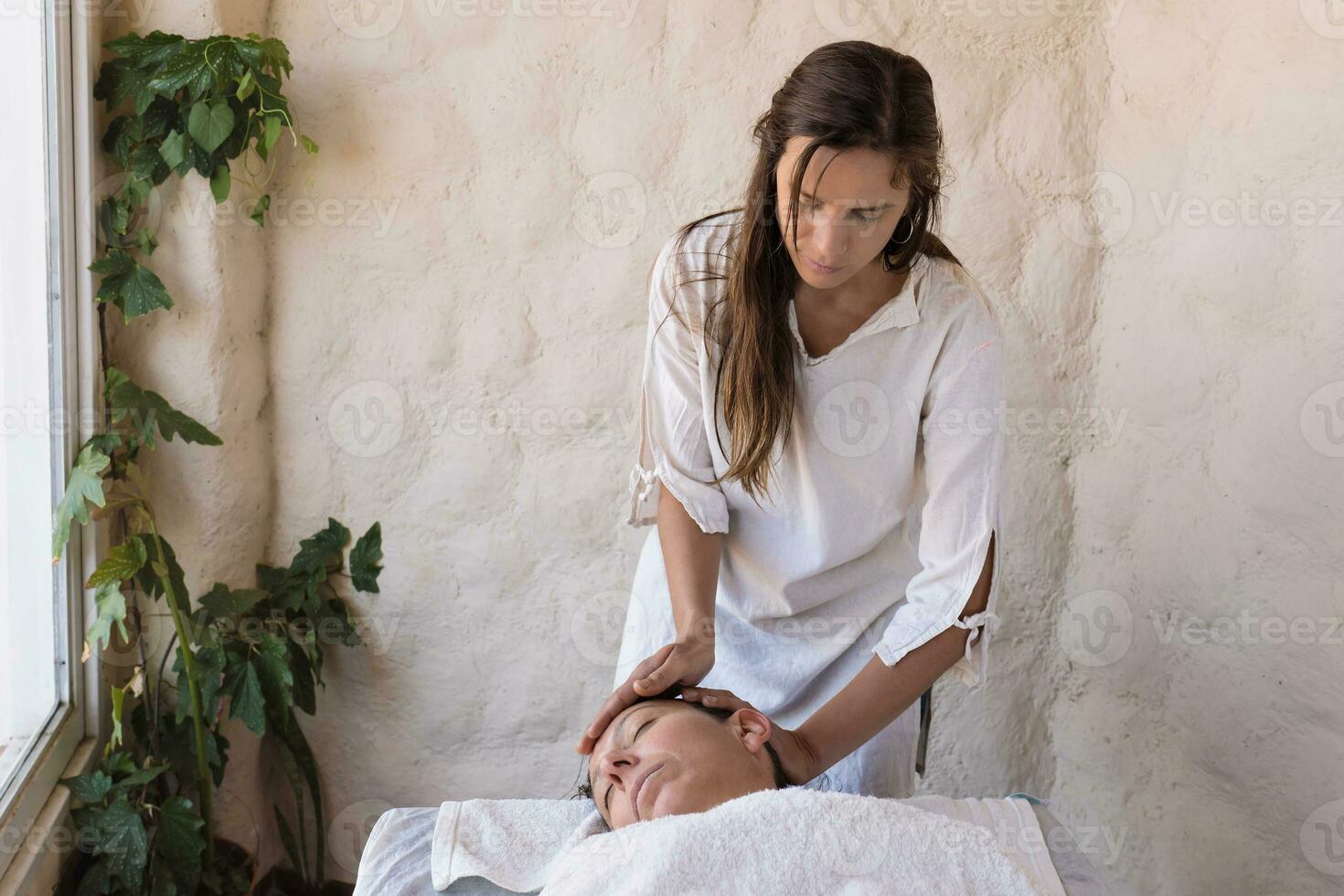 hermosa joven terapeuta ejecutando masaje en spa salón. foto