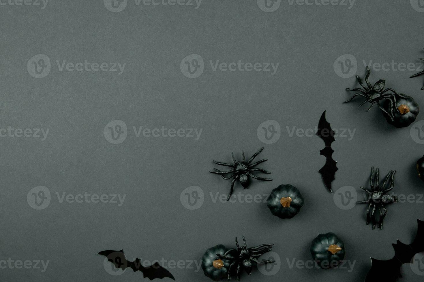 Happy halloween flat lay composition with black pumpkins, spiders and bats on dark background. Holiday concept. Top view. Copy space. photo