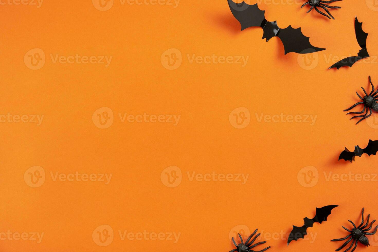 Happy halloween flat lay mockup with black spiders and bats on orange background. Holiday concept composition. Top view. Copy space. photo
