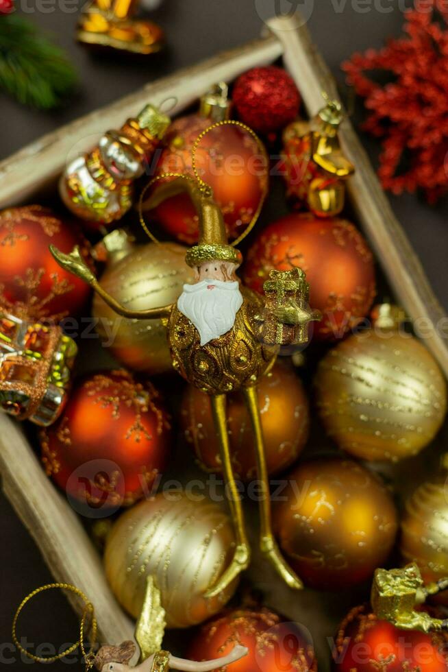 Christmas box with festive toys and decorations on dark background. Retro rustic style. Holiday, new year, xmas concept. Flat lay composition. Top view. photo