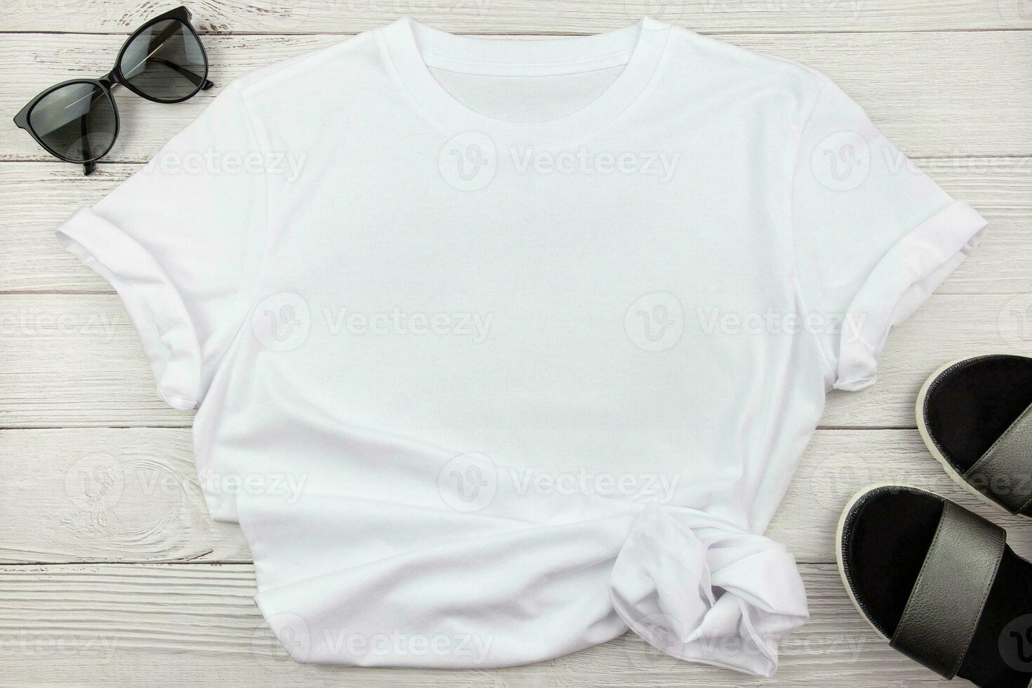 White womens cotton T Shirt mockup with summer shoes sandals and sunglasses on white wooden background. Design t shirt template, print presentation mock up. Top view flat lay. photo