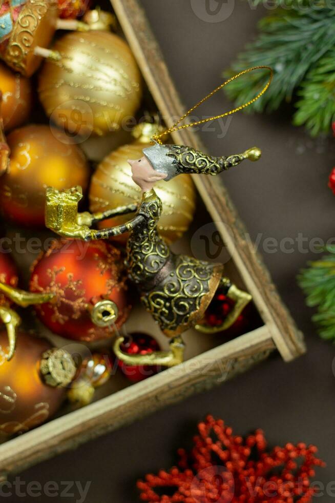 Christmas box with festive toys and decorations on dark background. Retro rustic style. Holiday, new year, xmas concept. Flat lay composition. Top view. photo