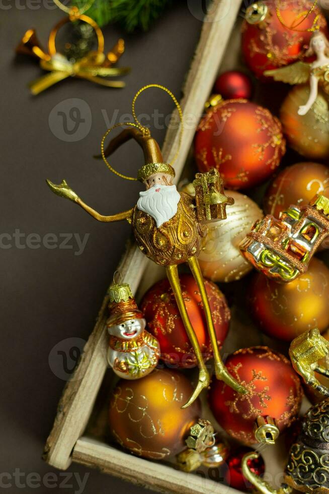 Christmas box with festive toys and decorations on dark background. Retro rustic style. Holiday, new year, xmas concept. Flat lay composition. Top view. photo