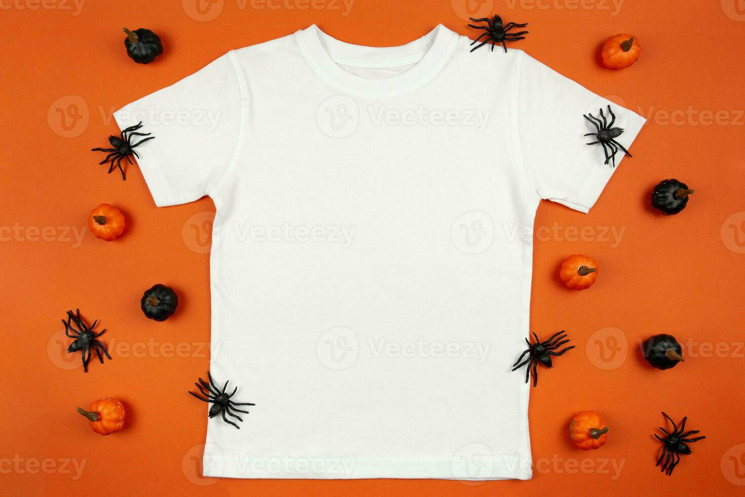 White womens cotton t-shirt halloween mockup with pumpkins and spiders on orange background. Design t shirt template, print presentation mock up. Top view flat lay. photo