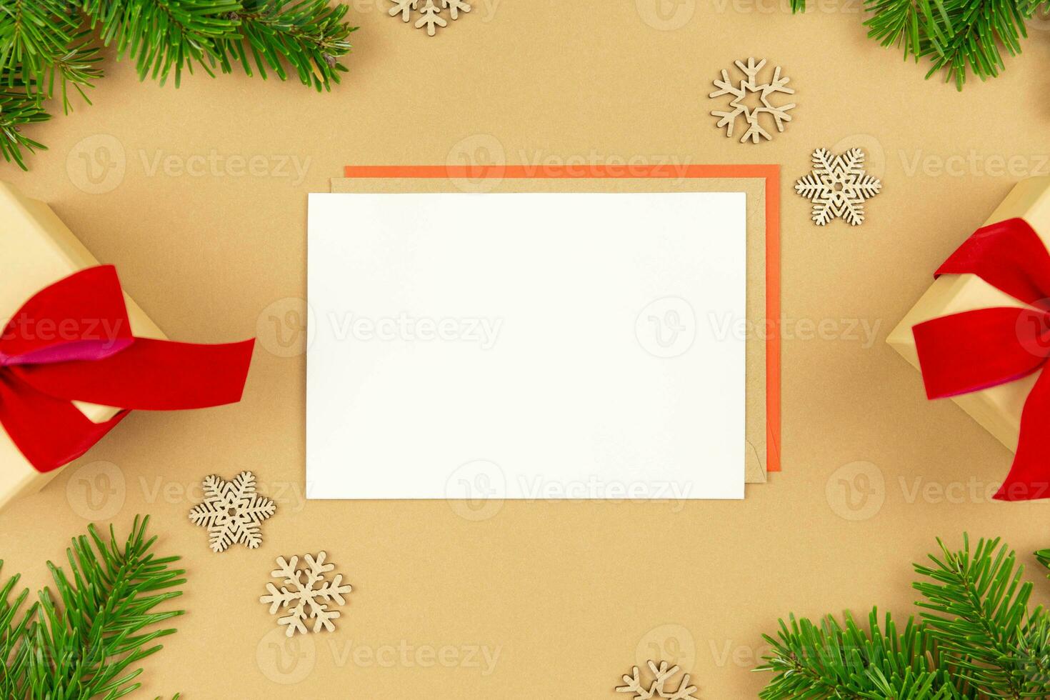 Christmas greeting card mockup and wrapped gift boxes with red ribbon and christmas tree branches decoration on paper background. Festive flat lay styled template composition. Top view. photo