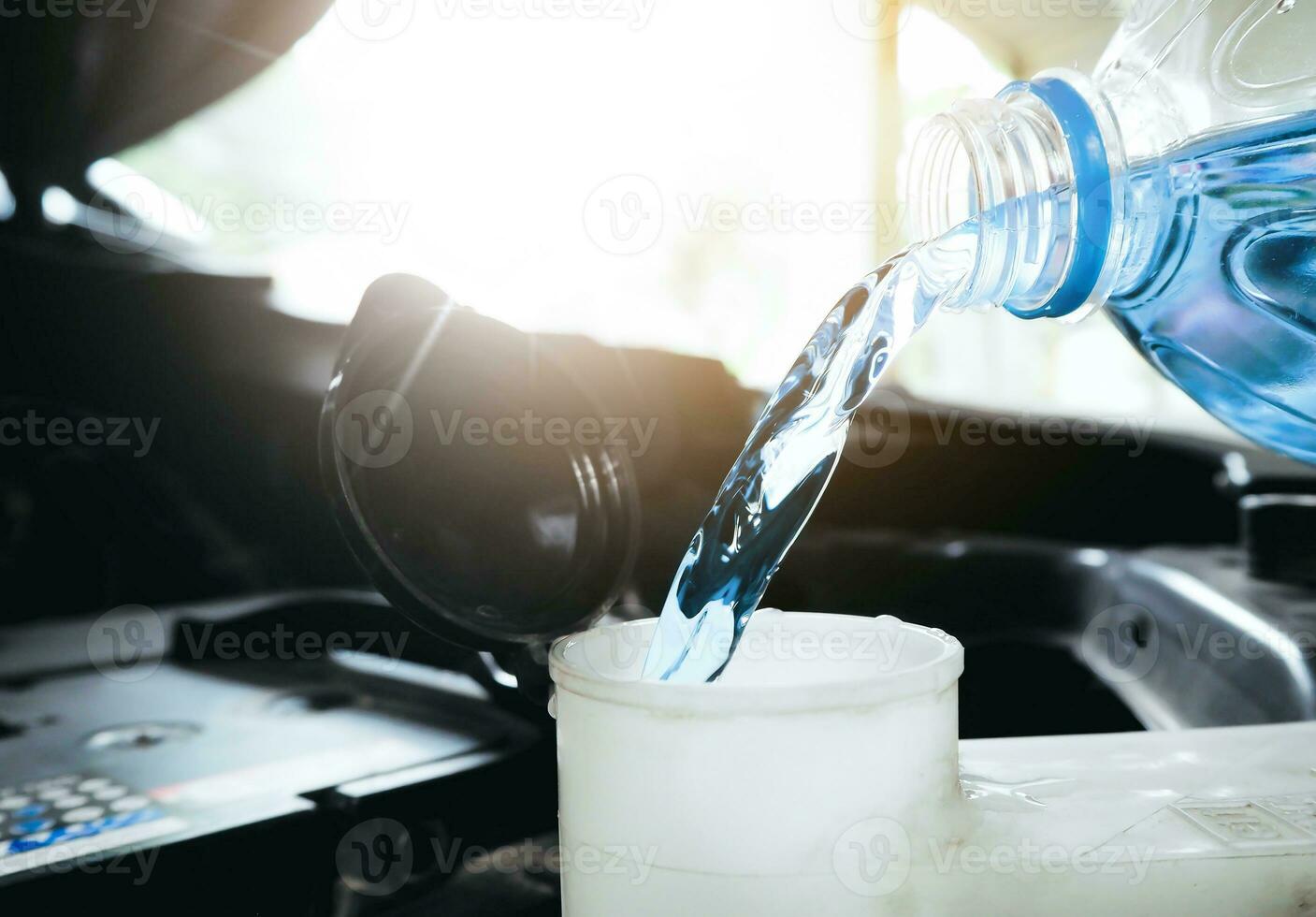 Mecánico llenando el depósito del líquido limpiaparabrisas del coche Stock  Photo