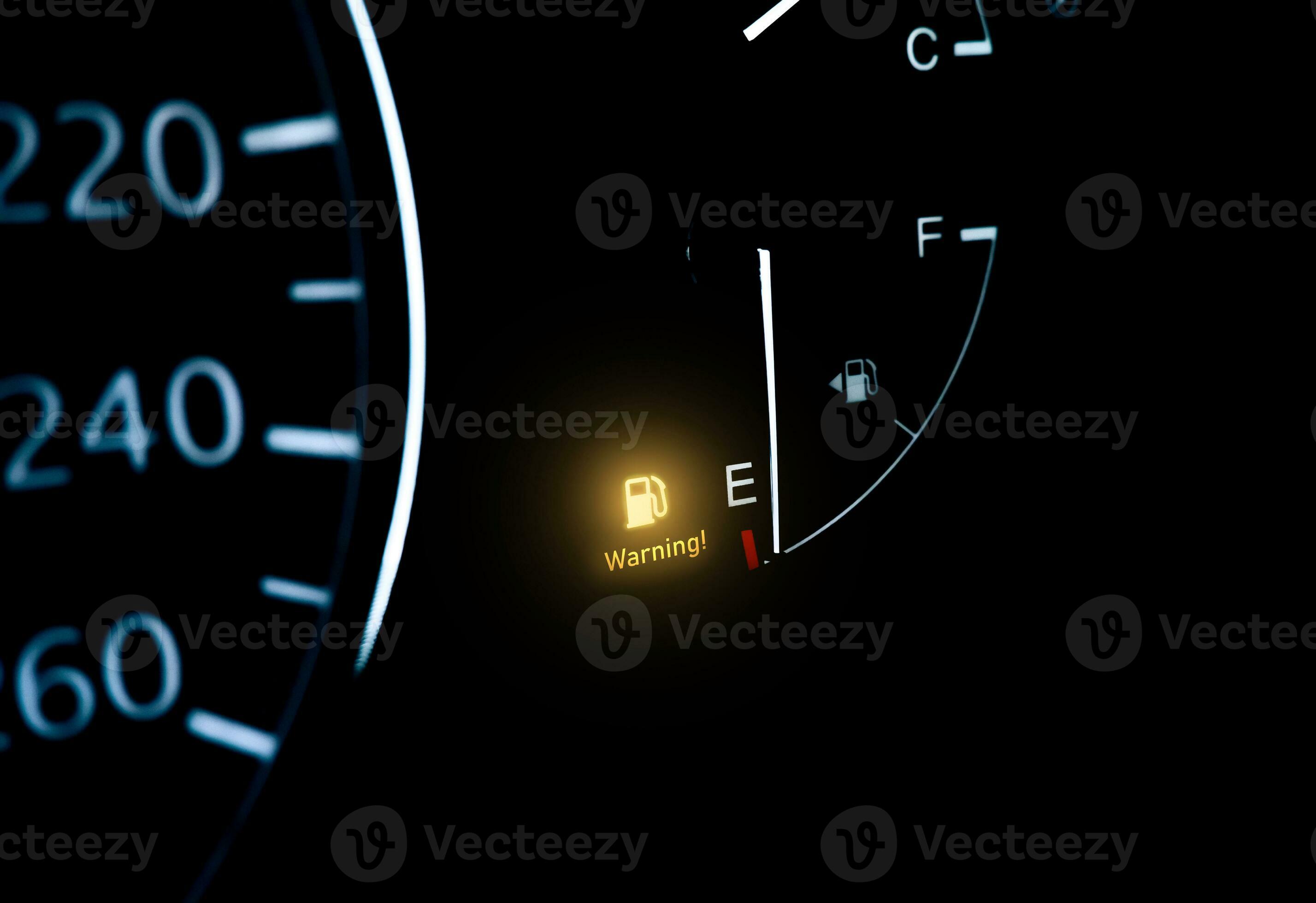 Low fuel indicator light on car dashboard with copy space below on