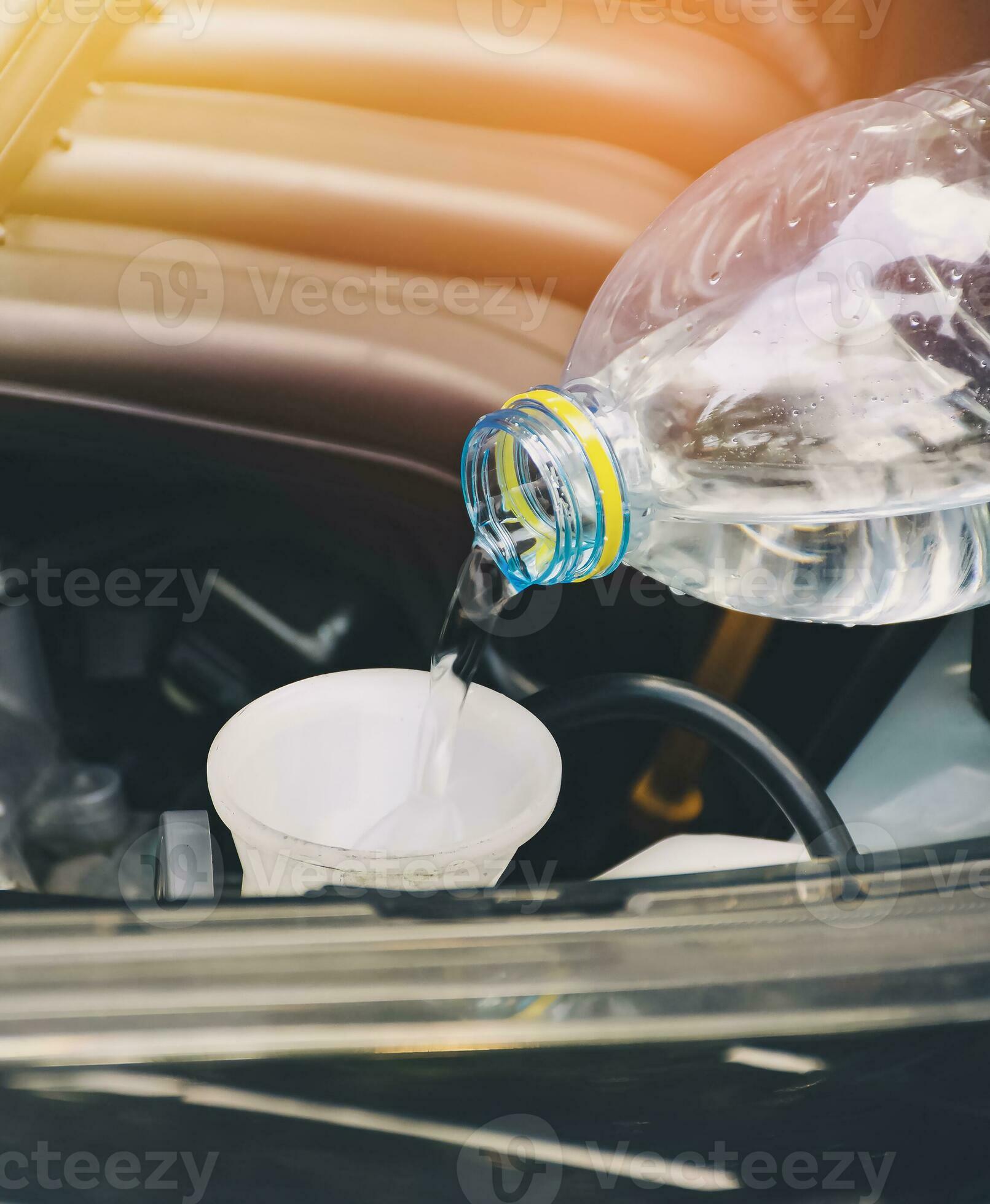 Mecánico llenando el depósito del líquido limpiaparabrisas del coche Stock  Photo