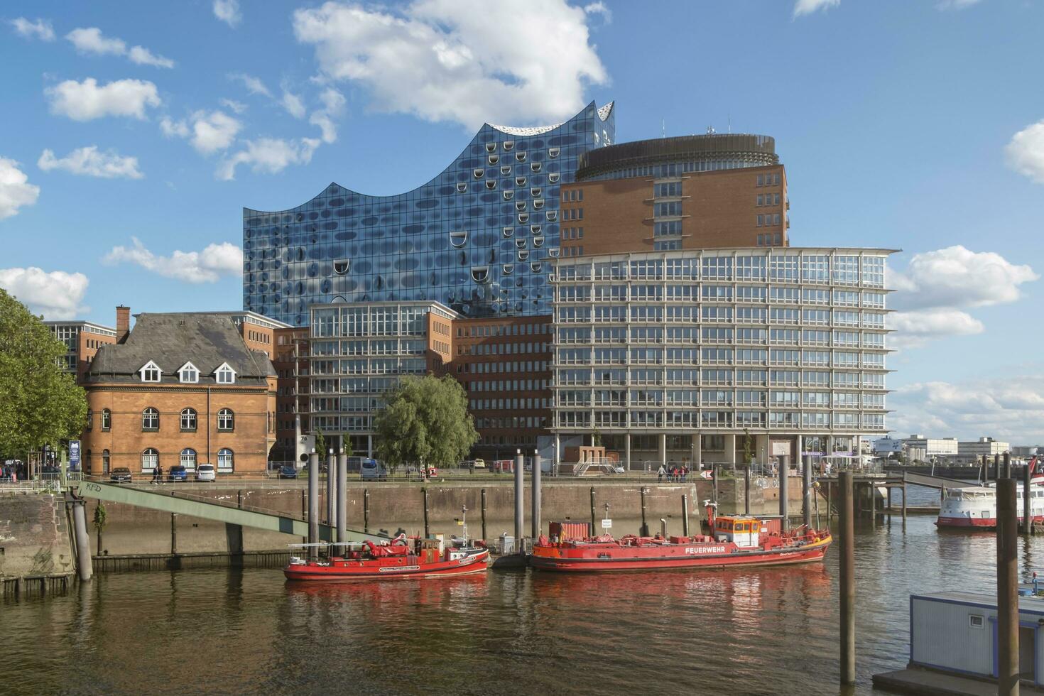 HAMBURG, GERMANY - 29 MAY 2019 Hamburg Harbor Fire Fighter Boats and Elbphilharmonie Concert Hall in the background photo