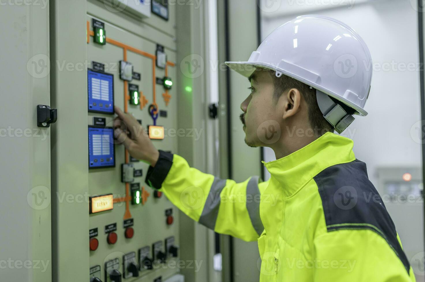 Electrical engineer man checking voltage at the Power Distribution Cabinet in the control room,preventive maintenance Yearly,Thailand Electrician working at company photo