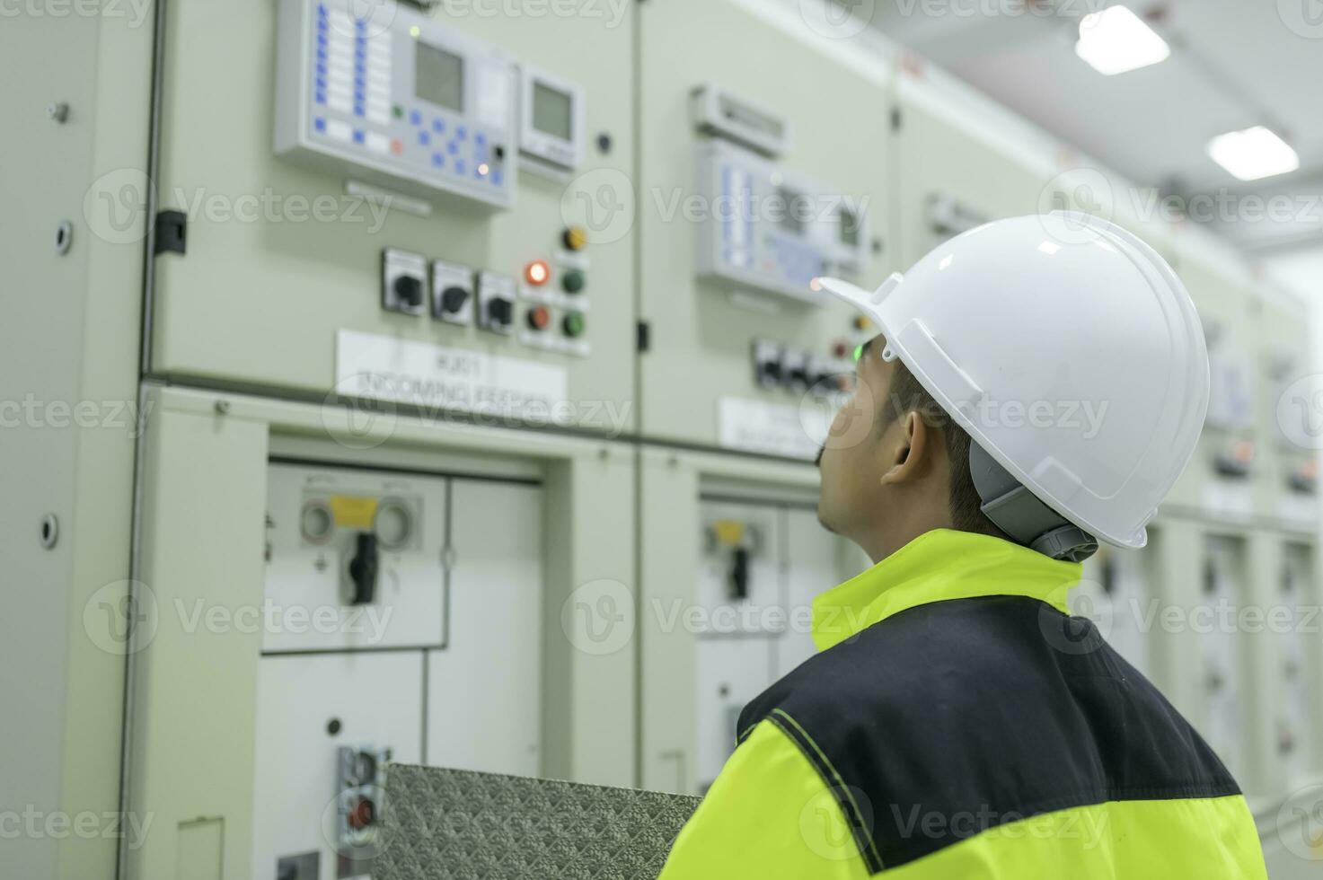 Electrical engineer man checking voltage at the Power Distribution Cabinet in the control room,preventive maintenance Yearly,Thailand Electrician working at company photo