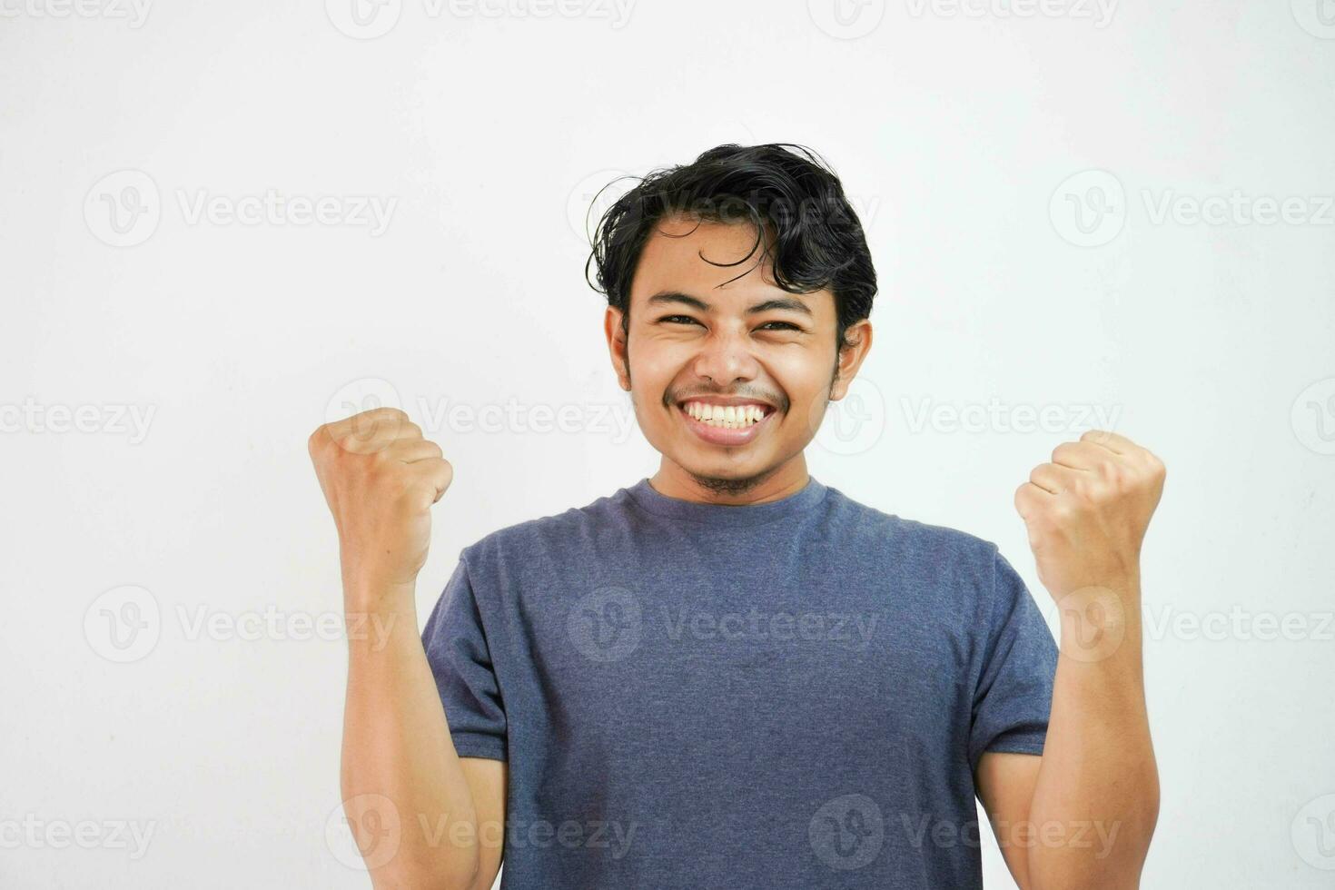 Young handsome asian man wearing casual standing over isolated white background very happy and excited doing winner gesture with arms raised, smiling and screaming for success. Celebration photo