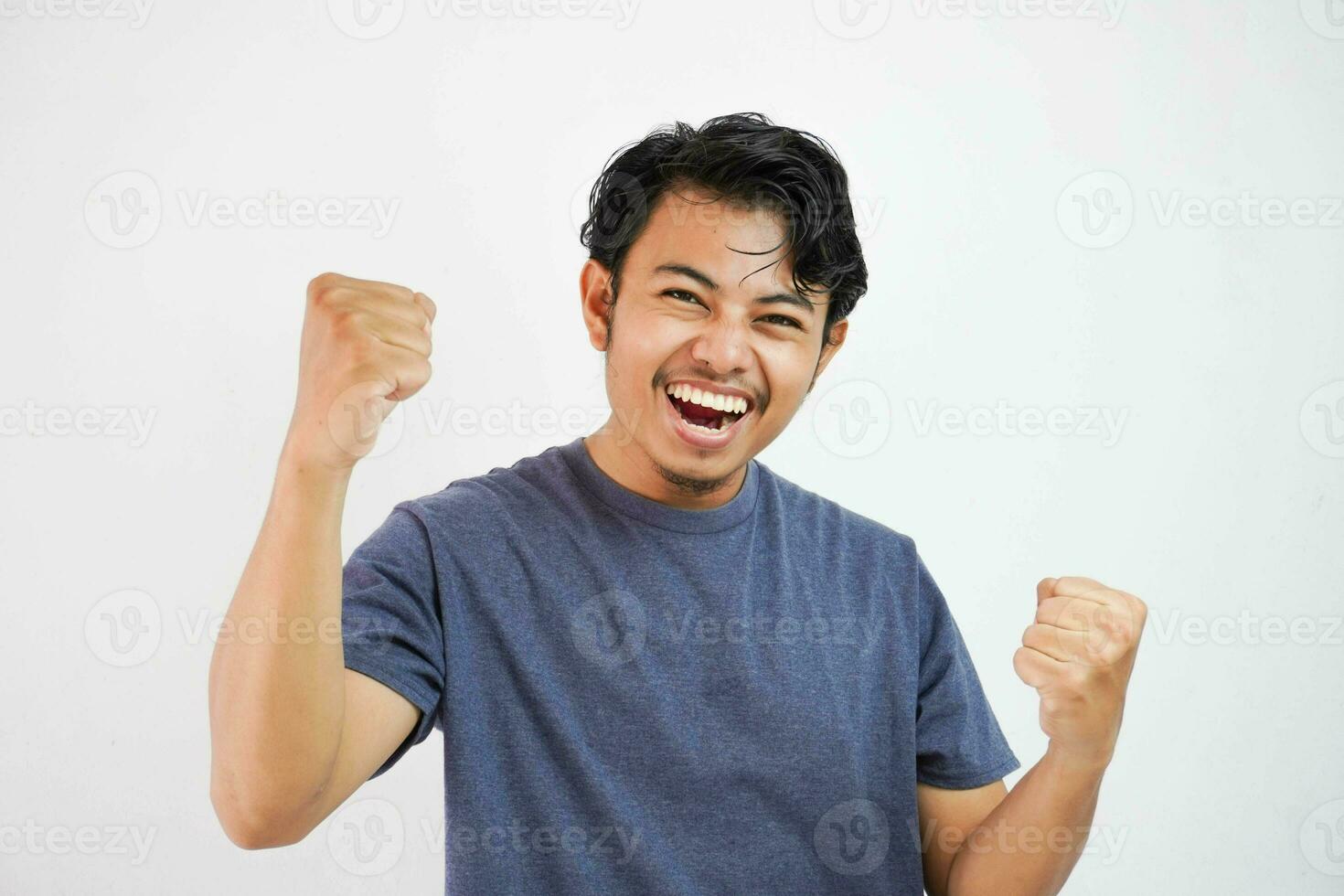 Young handsome asian man wearing casual standing over isolated white background very happy and excited doing winner gesture with arms raised, smiling and screaming for success. Celebration photo