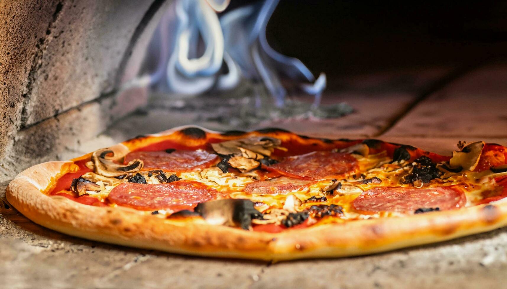 macro photo of pizza in a wood-fired oven with light smoke