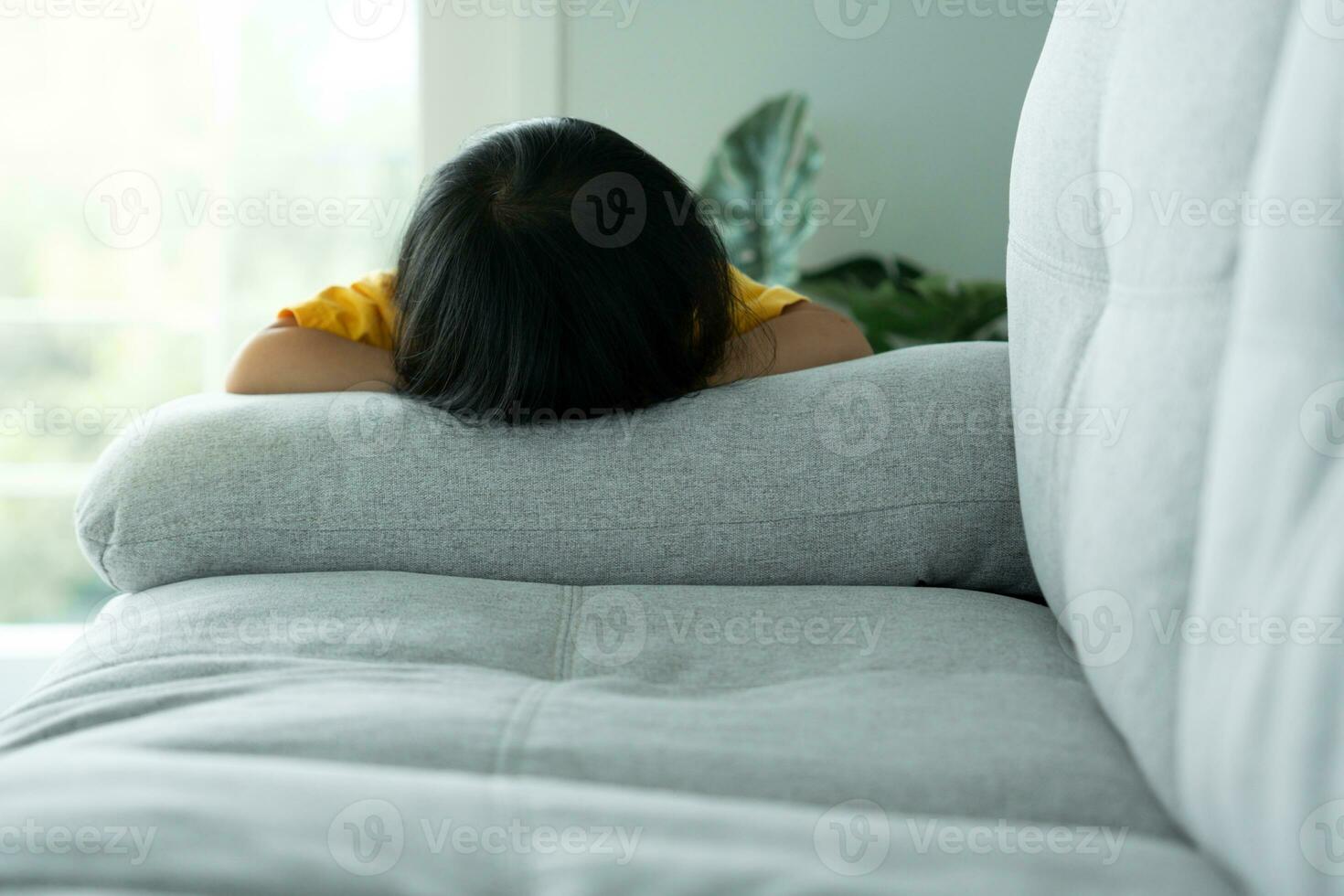 little asian children kid playing hide and seek standing behind the sofa, Adorable child having fun in the home. happy family have fun with kids, activity, learning, activity, game, meditation photo