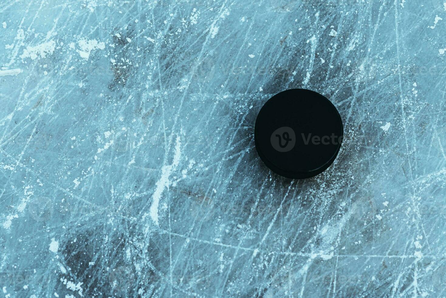 black hockey puck lies on ice at stadium photo