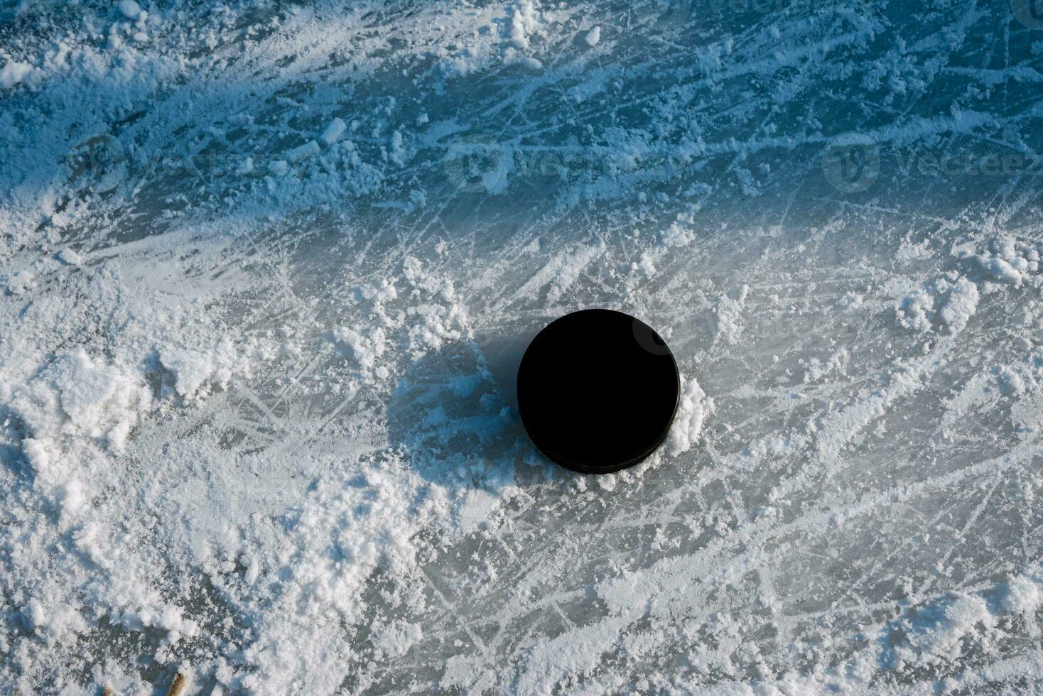 hockey puck lies on the snow close-up photo