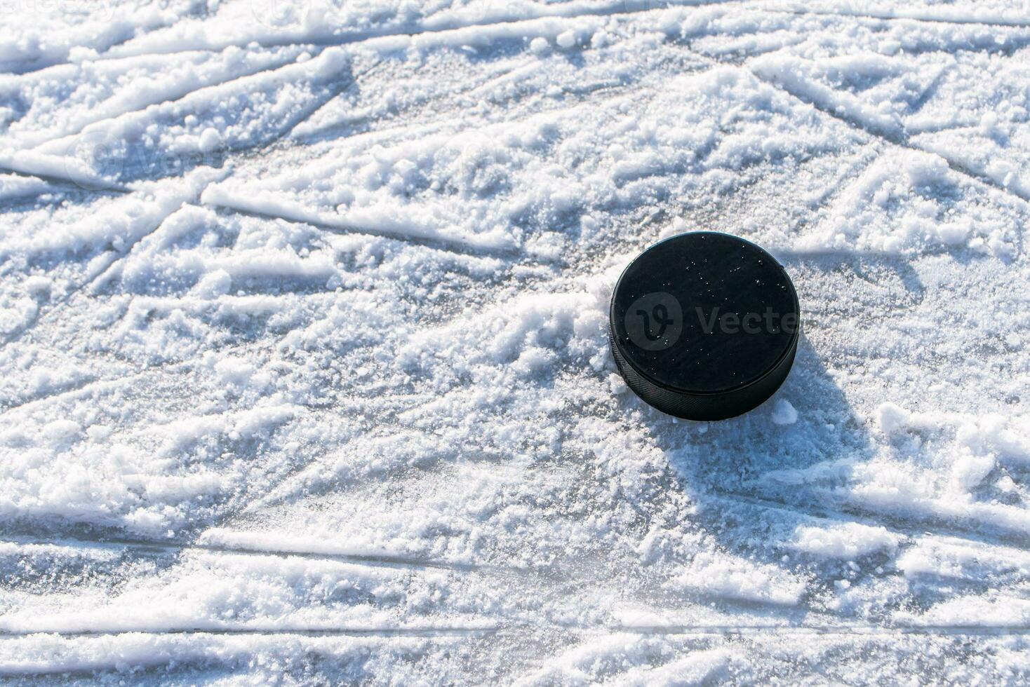 hockey puck lies on the snow close-up photo